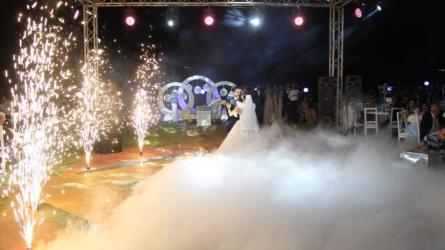 a couple dancing on a stage with fireworks