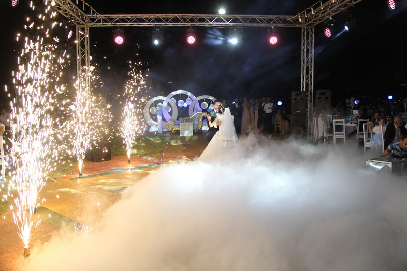 a couple dancing on a stage with fireworks