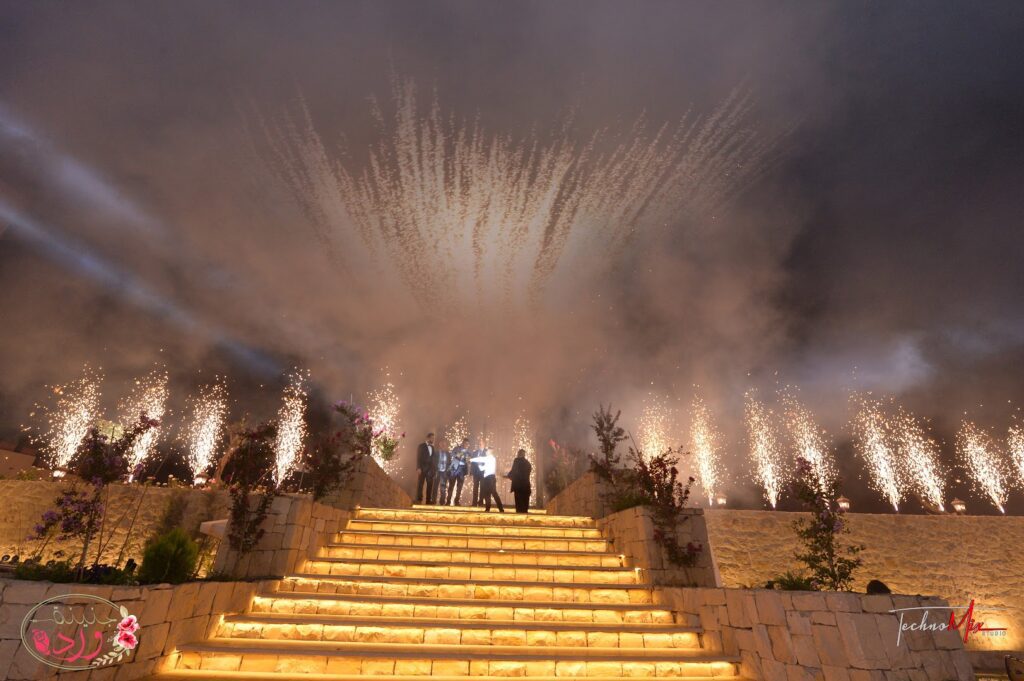 a group of people standing on a staircase with fireworks in the sky