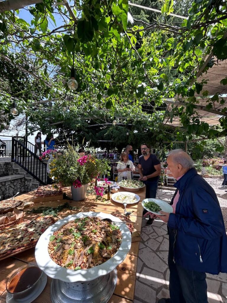 a group of people standing around a table with food