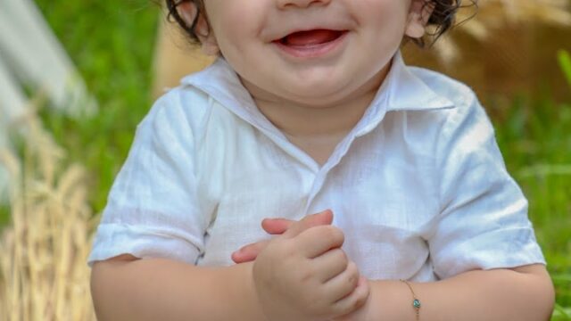 a baby sitting in the grass