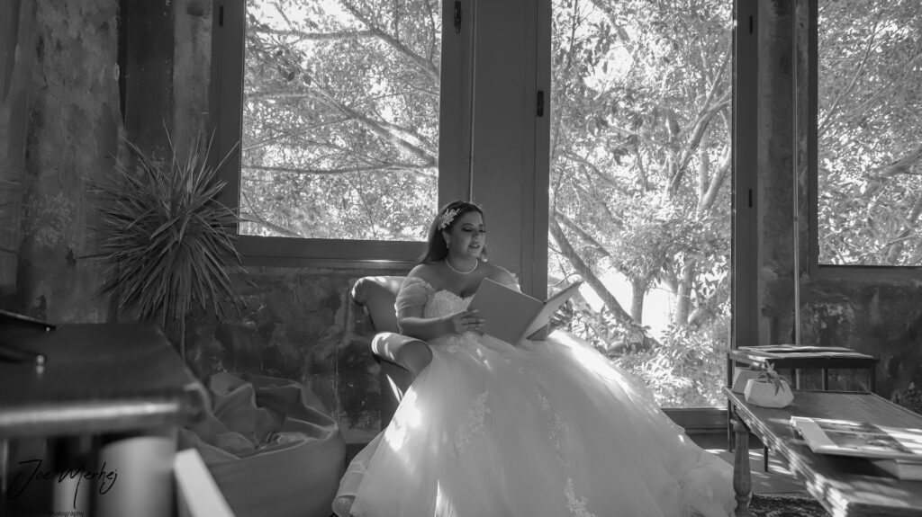 a woman in a wedding dress sitting in a chair reading a book