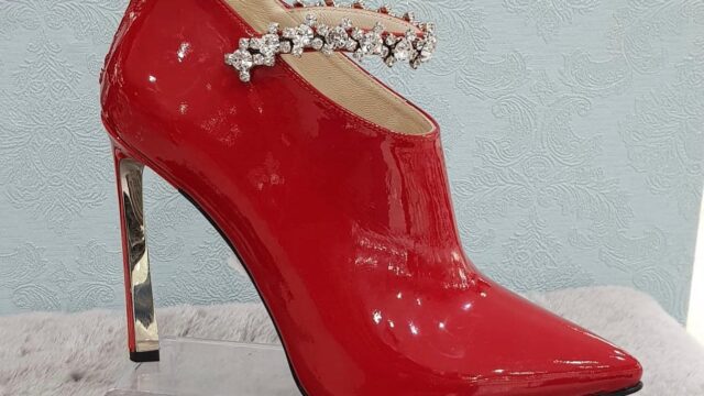 a red high heeled shoe with a jewel on the side