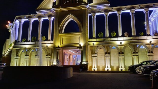 a building with columns and a fountain at night