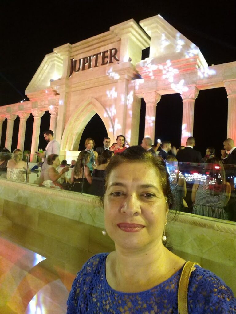 a woman taking a selfie in front of a large white building