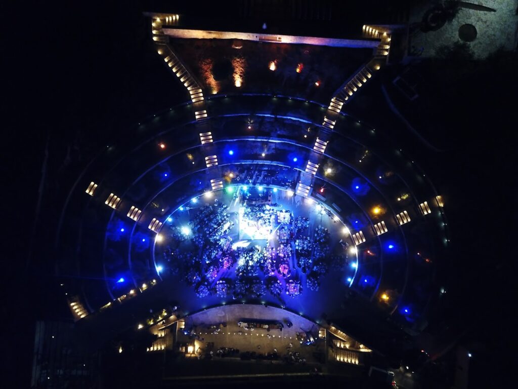 an aerial view of a circular building with lights