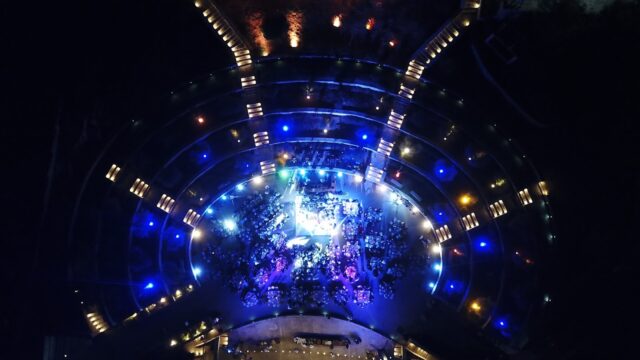 an aerial view of a circular building with lights