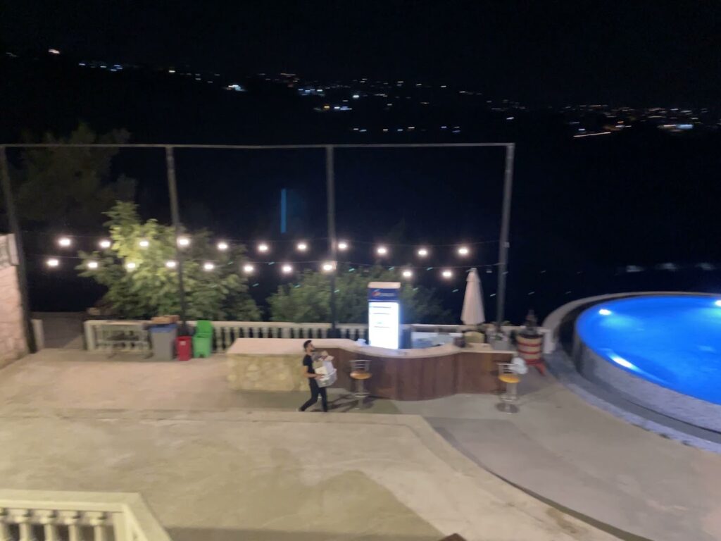 a person walking near a pool at night