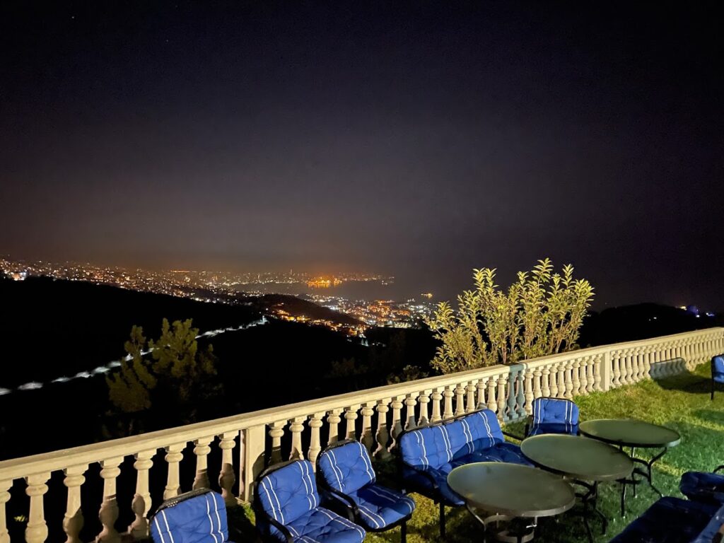 a table and chairs on a balcony overlooking a city