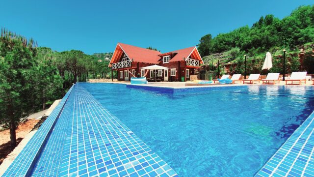 a pool with a house and trees in the background