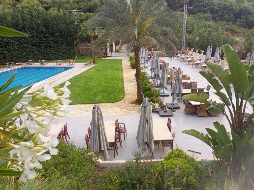 a pool with tables and chairs and umbrellas