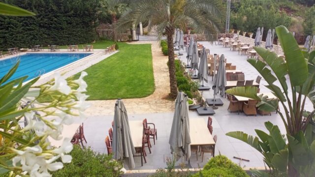 a pool with tables and chairs and umbrellas