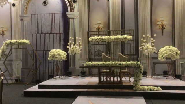 a stage with a table and chairs and flowers