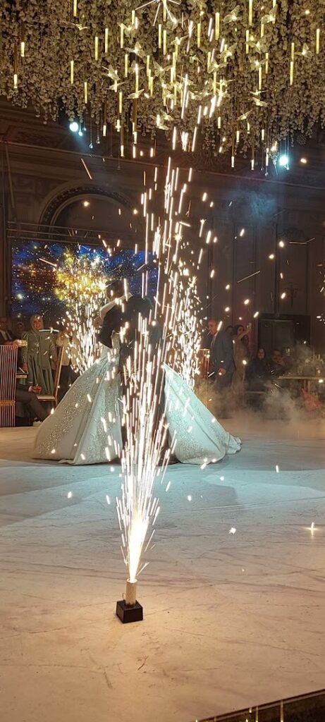 a couple in wedding dresses dancing with fireworks