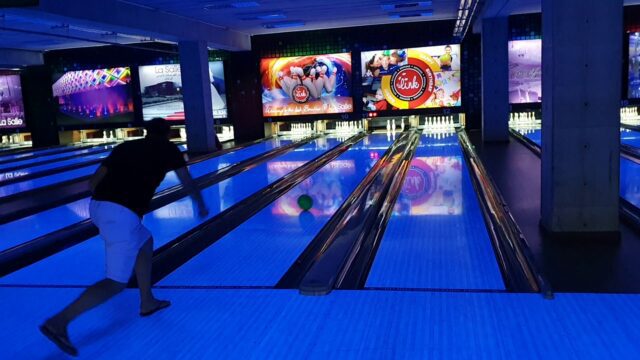 a man throwing a ball in a bowling alley