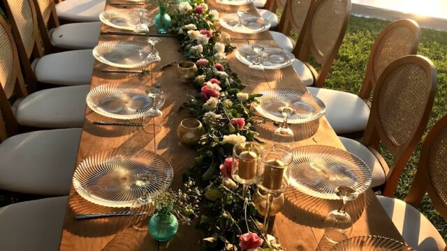 a long table with plates and flowers on it