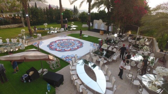 a group of people outside with tables and chairs