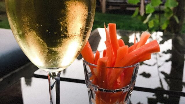 a glass of wine and snacks on a table