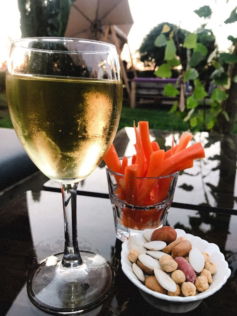 a glass of wine and snacks on a table