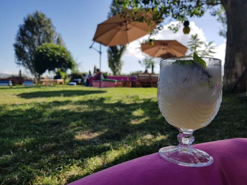 a glass of ice cream on a pink surface