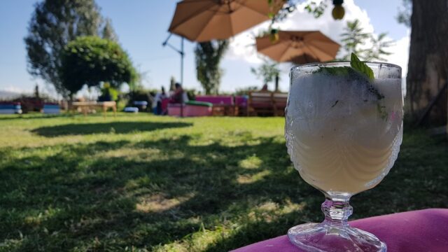 a glass of ice cream on a pink surface