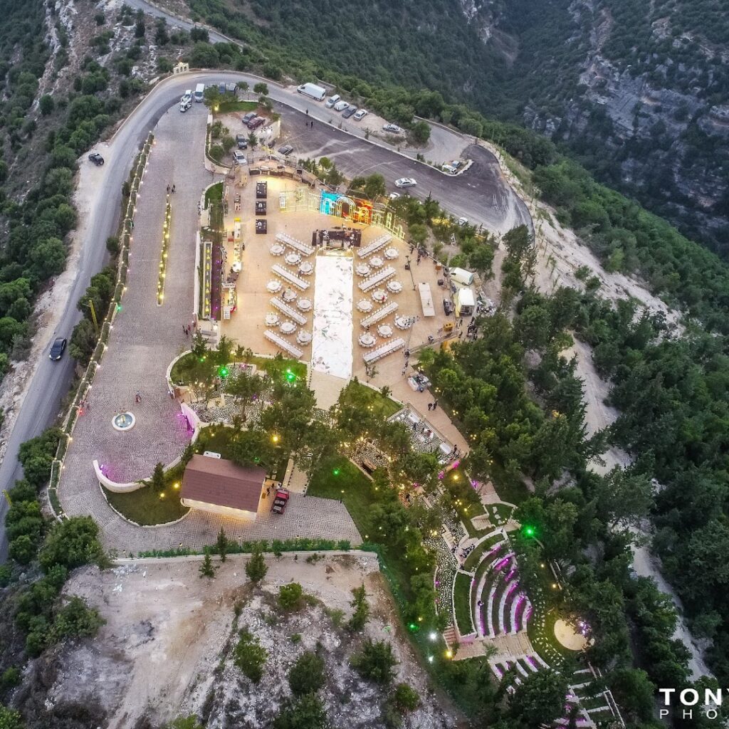 aerial view of a large building with tables and chairs on a mountain