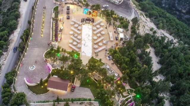 aerial view of a large building with tables and chairs on a mountain