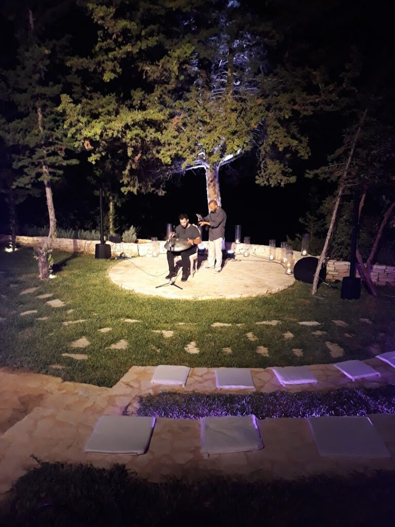 a group of people standing on a patio with a tree in the background