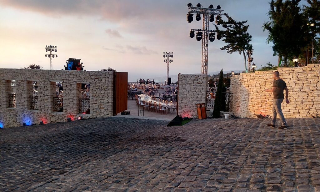 a stone wall with lights and a large area with a crowd of people