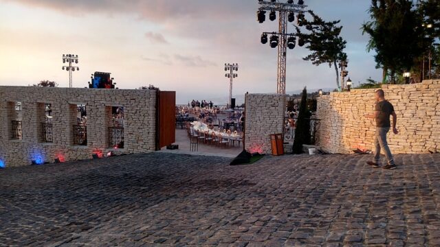 a stone wall with lights and a large area with a crowd of people