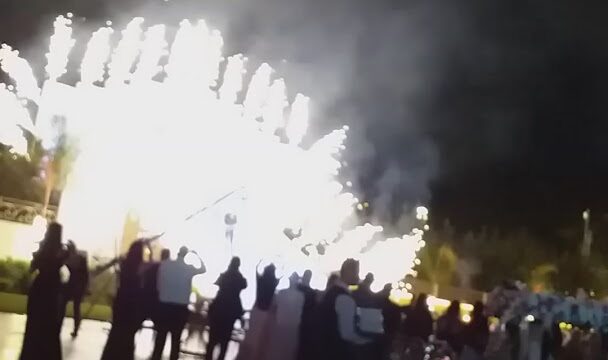 a group of people standing in front of a fireworks display