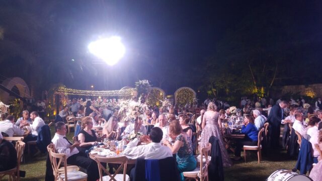 a group of people sitting at tables outside at night