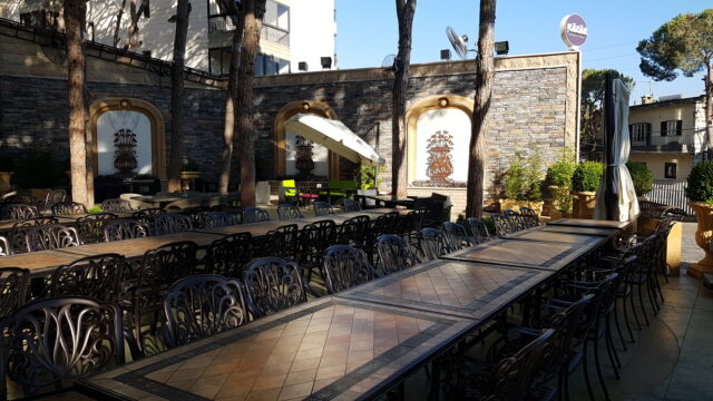 A group of tables and chairs outside Le43 Catering.