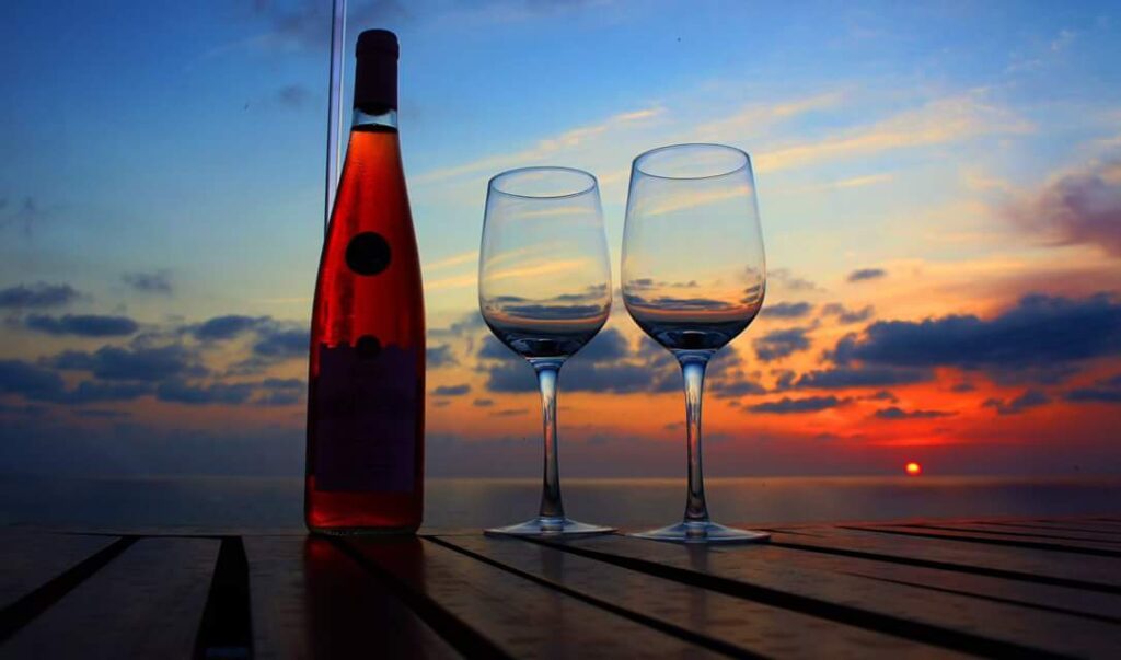 a bottle and two wine glasses on a table