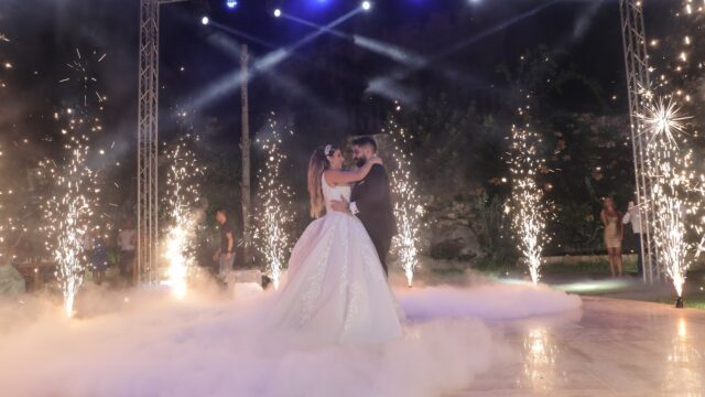 a man and woman dancing on a stage with fireworks