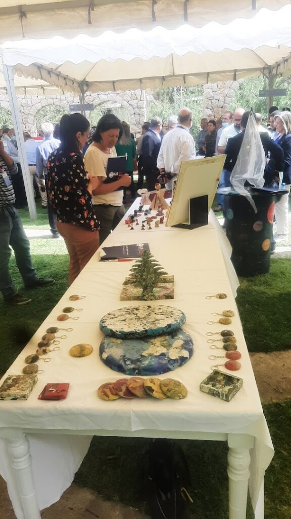 a group of people standing around a table with art items