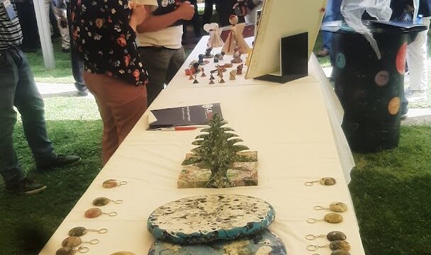 a group of people standing around a table with art items