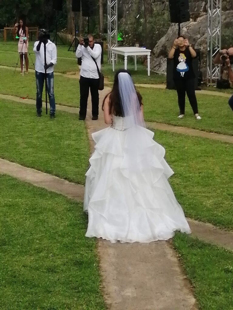 a woman in a wedding dress walking down a path