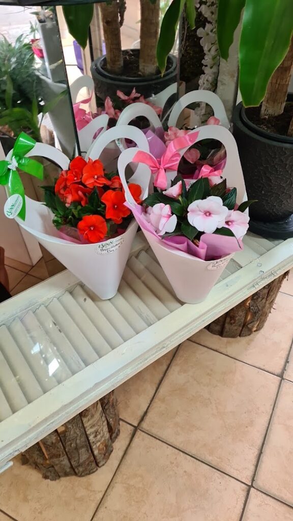 a group of flowers in white paper bags