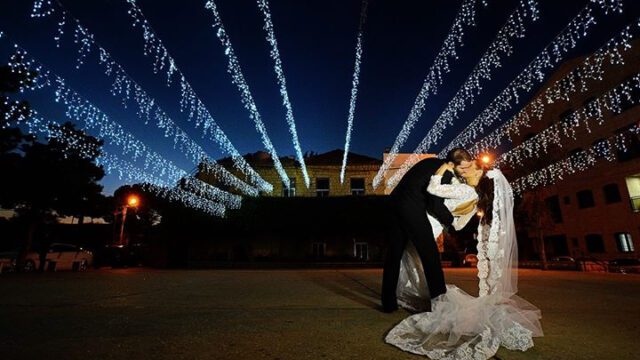 a man and woman kissing in front of lights