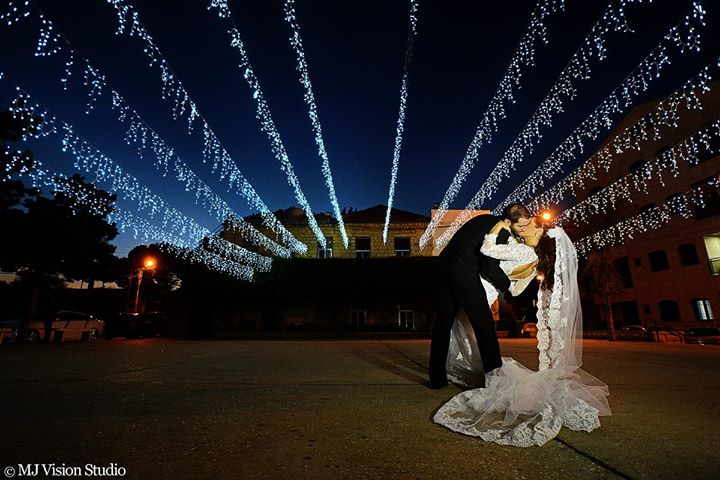 a man and woman kissing in front of lights