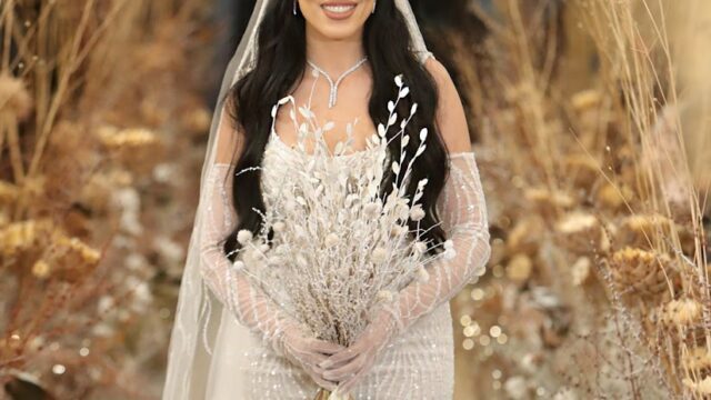 a woman in a white dress holding a bouquet of flowers