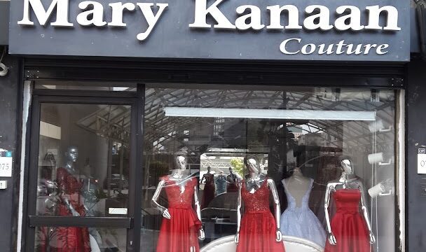 a store front with mannequins in red dresses