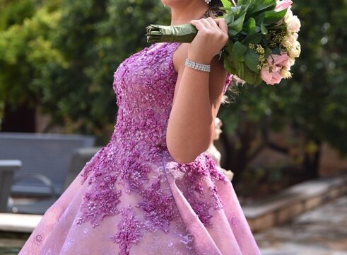 a woman in a purple dress holding flowers