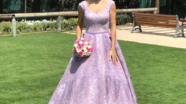 a woman in a purple dress holding a bouquet of flowers