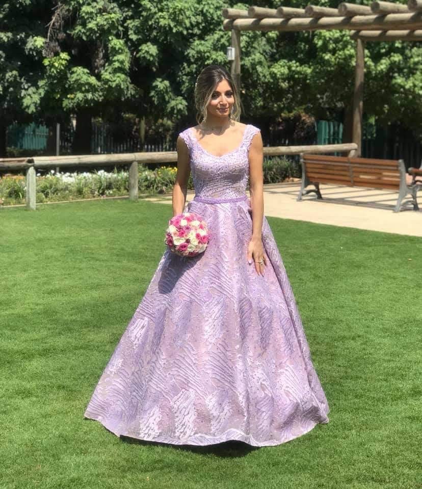 a woman in a purple dress holding a bouquet of flowers