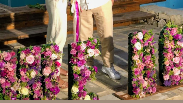 a couple of people standing next to flowers