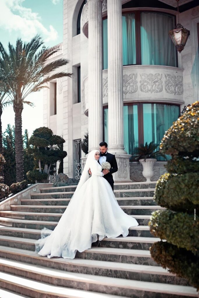 a man and woman in wedding attire standing on stairs in front of a building