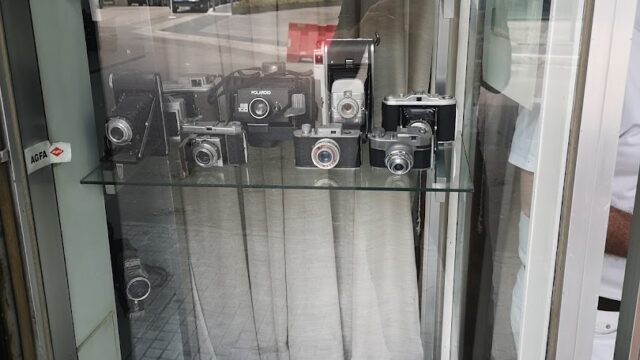 A glass case with a group of cameras showcasing the Middle East Photo Center.