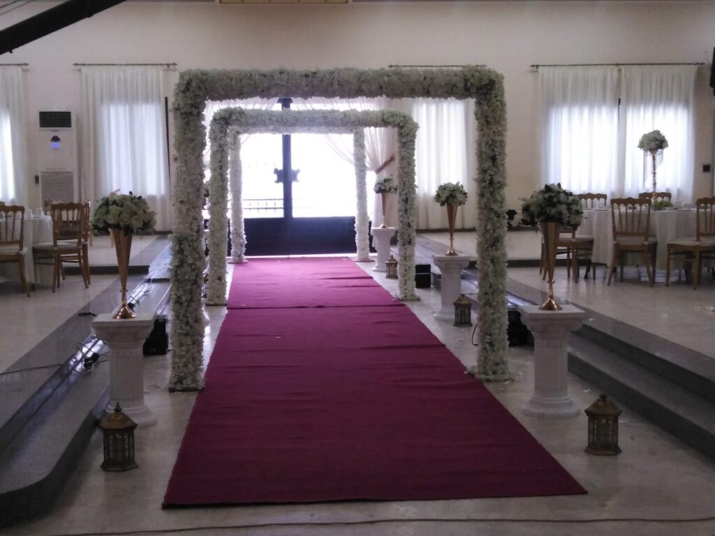 a wedding ceremony with a red carpet and white flowers